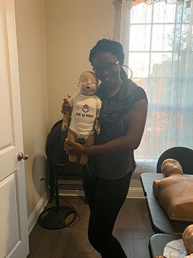 Woman Holding Infant CPR Dummy
